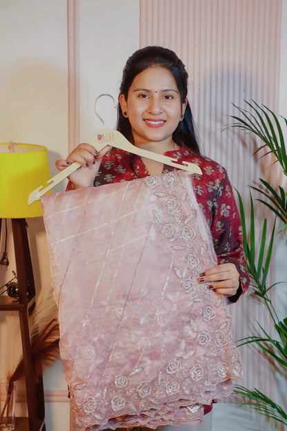 Dusky pink shimmer saree, folded on a hanger