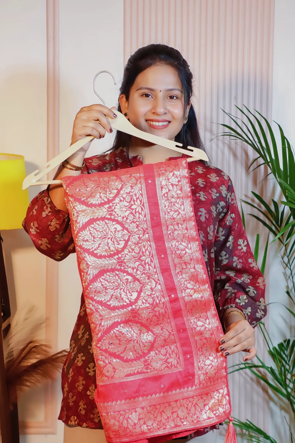 Peach pink silk zari saree, folded on a hanger