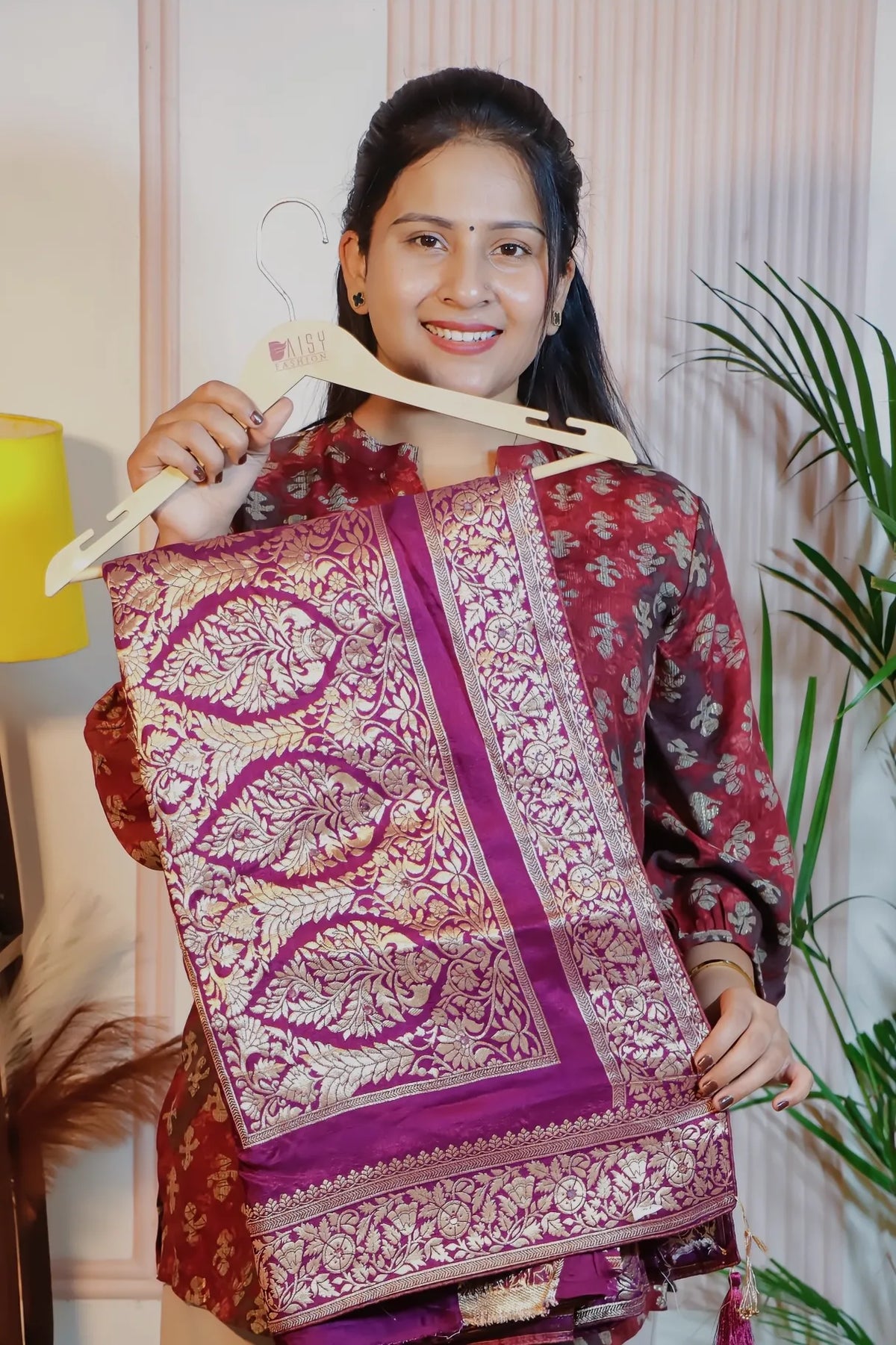 Royal purple silk saree, folded on a hanger to show the zari weave