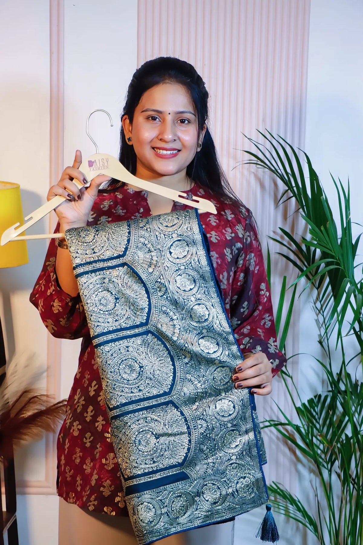 Teal blue silk saree, folded on a hanger to show the zari border