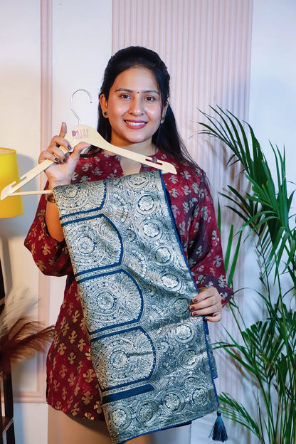 Teal blue silk saree, folded on a hanger to show the zari border