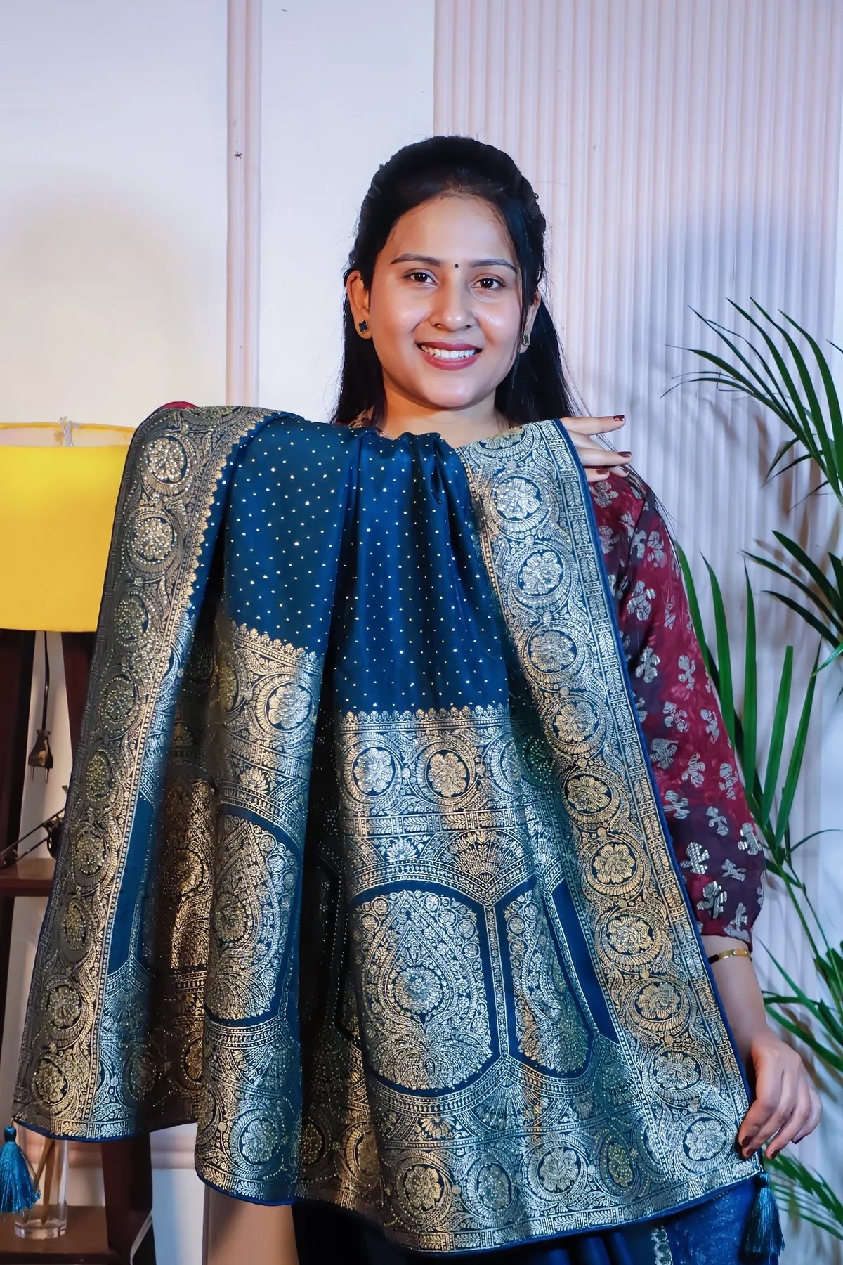 Teal blue silk saree, pallu held open to show the zari weave