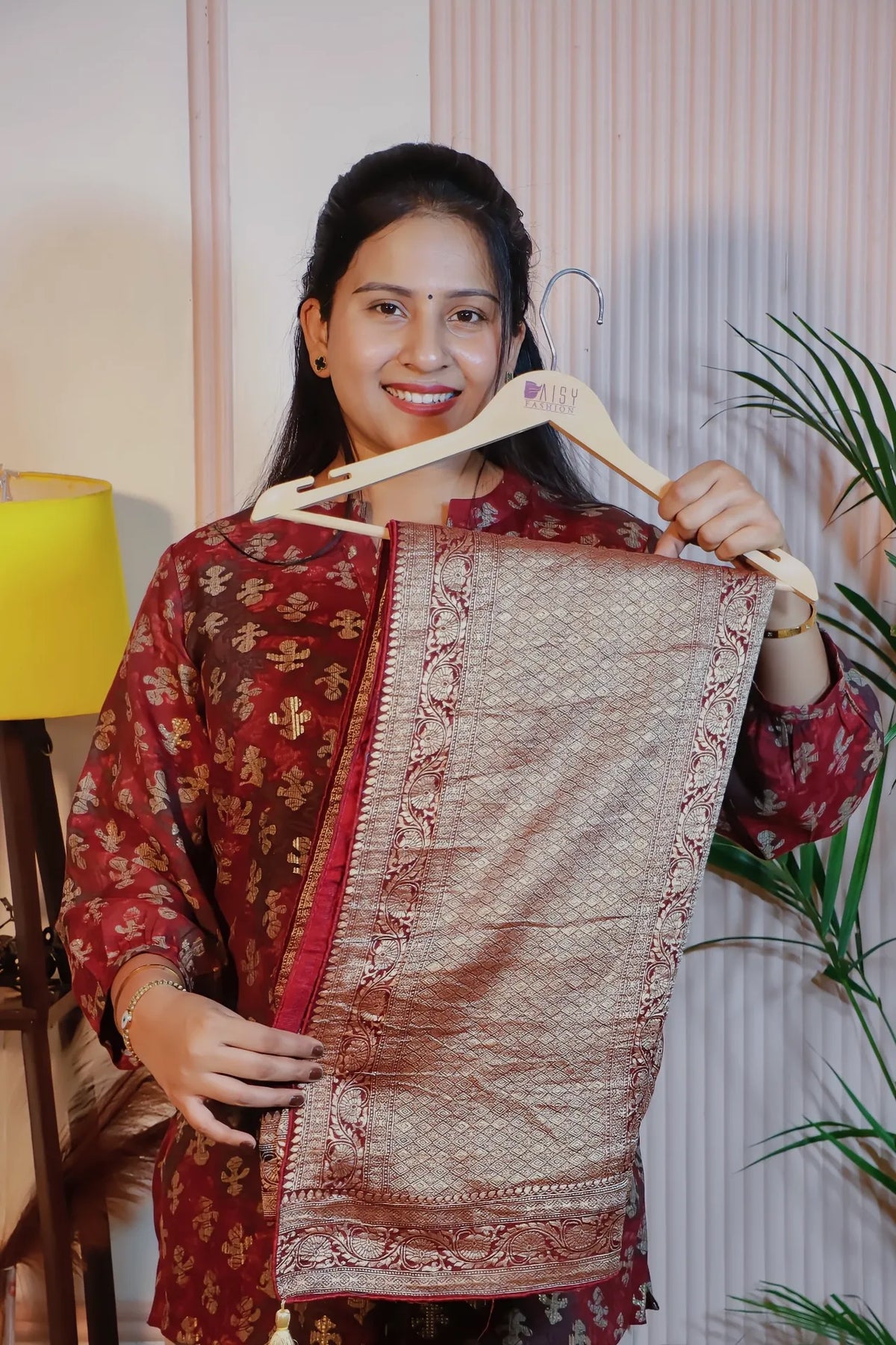 Maroon georgette saree, folded on a hanger