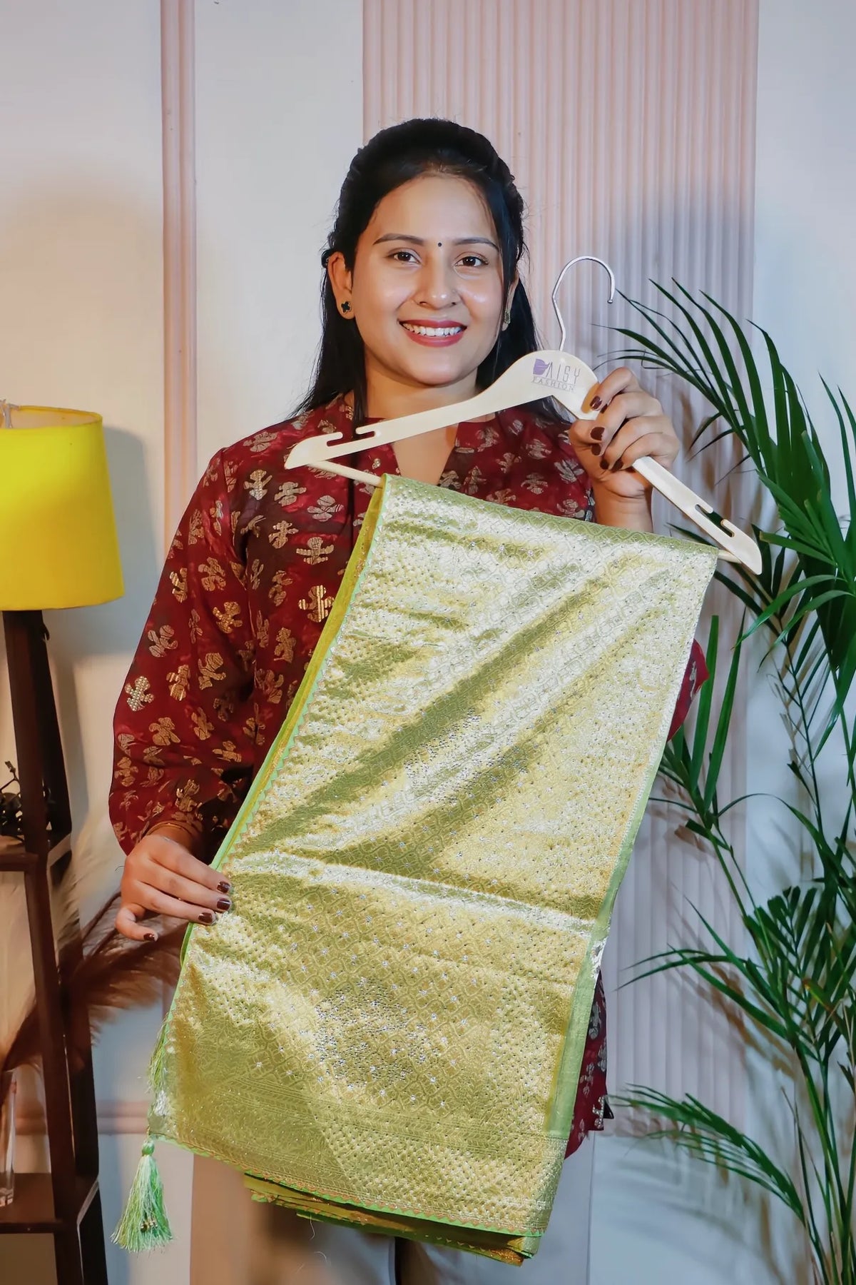Pista green silk saree, folded on a hanger to show the zari weave