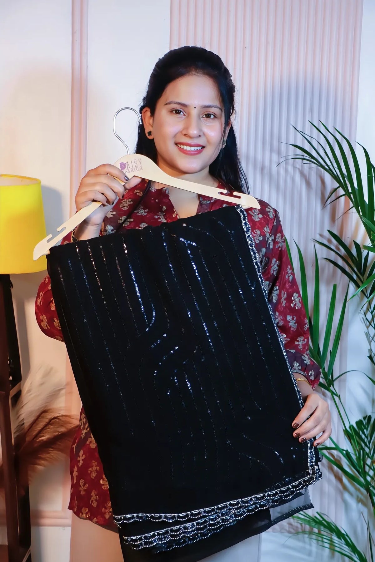 Black georgette sequin saree, folded on a hanger