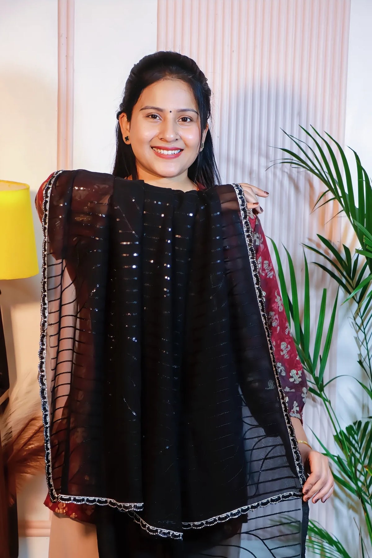 Black georgette sequin saree, held open to show the sequin work