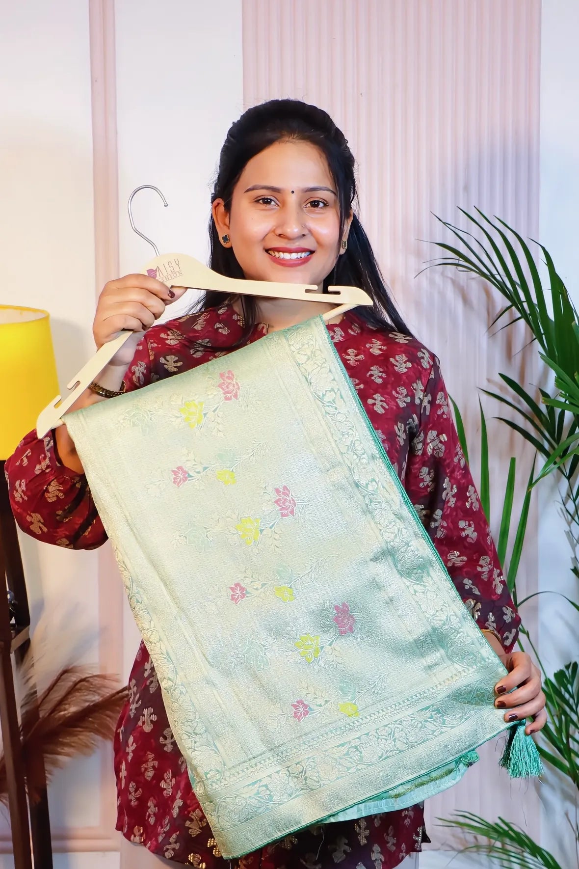 Mint green silk saree, folded on a hanger to show the woven motifs