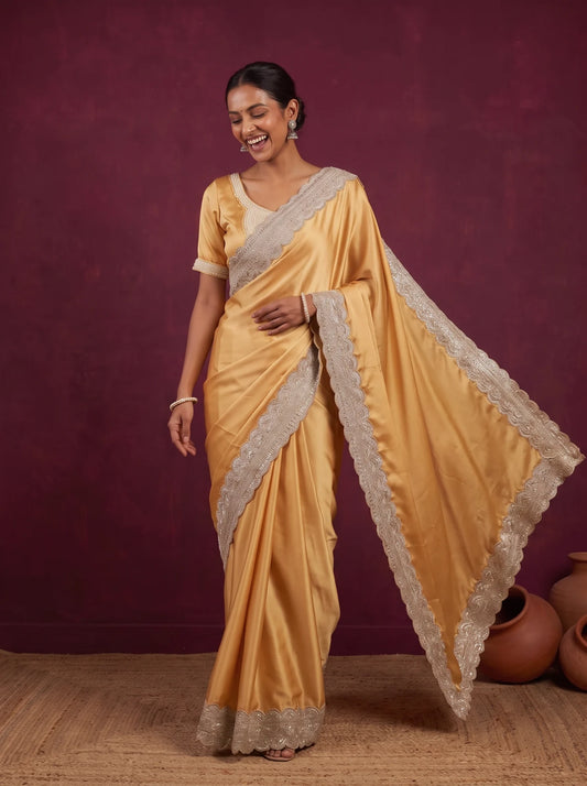 Golden satin saree, pallu held out showing the scalloped border